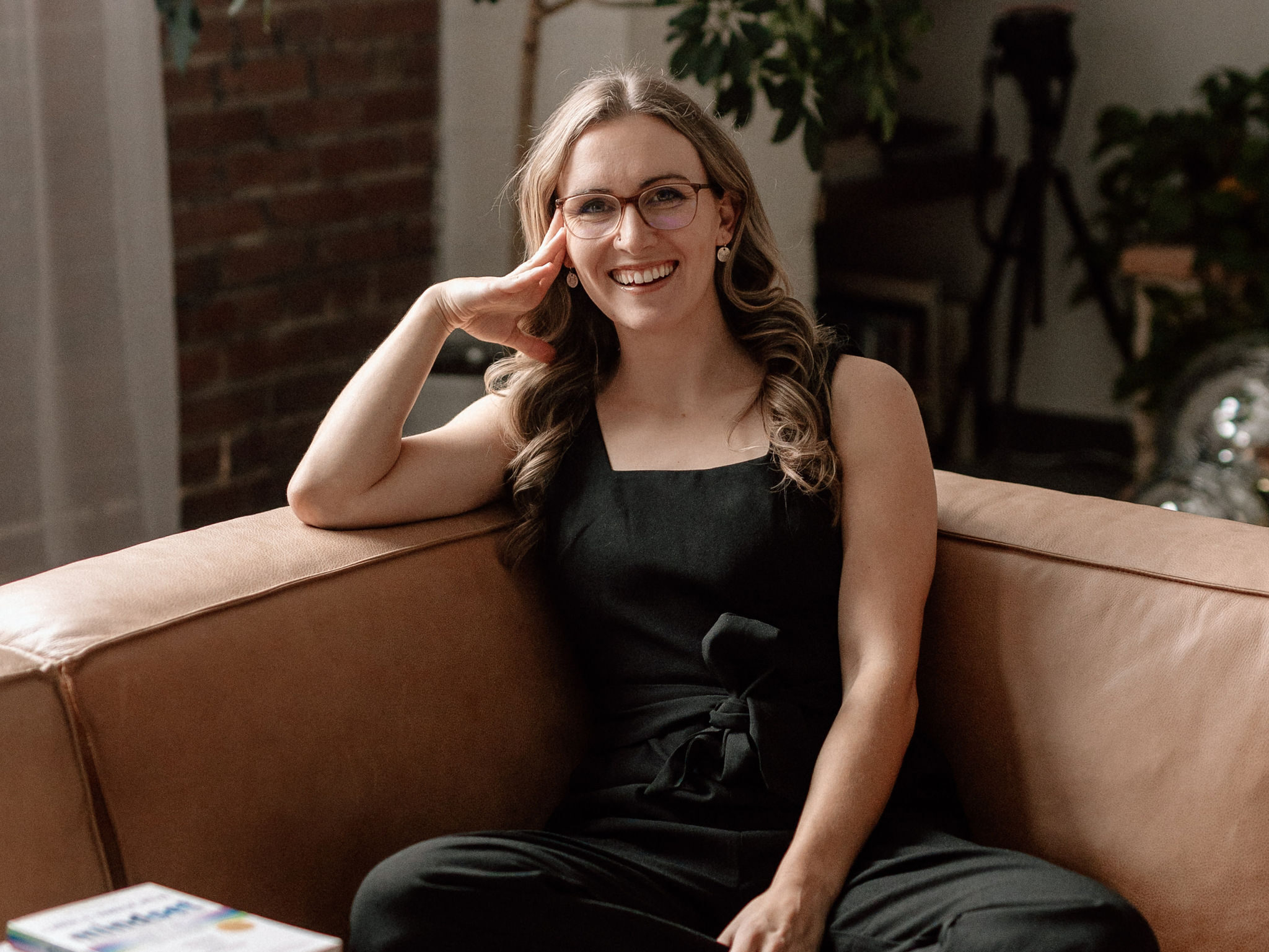 Lauren Dewey sitting on a couch, teaching why you shouldn't invest or use pre-made course content to scale your business